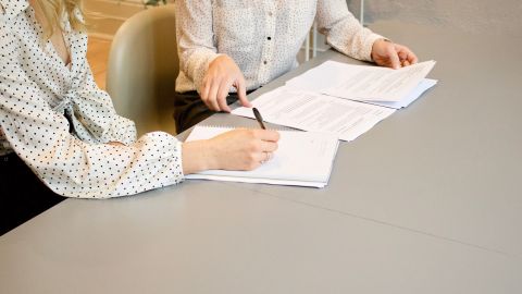 Foto de dos mujeres firmando un contrato