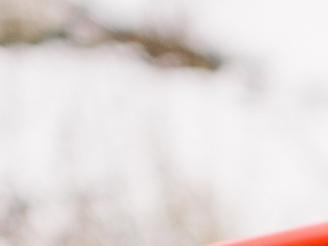 Foto de la batería de un auto conectada a unos cables auxiliares