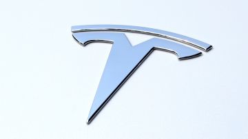 Foto del logo de Tesla sobre un auto blanco
