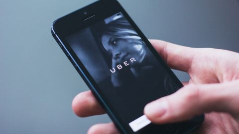 Foto de la mano de una persona con un teléfono que muestra la aplicación de Uber