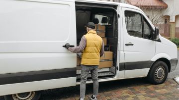Foto de un repartidor cerrando la puerta de carga de su vehículo