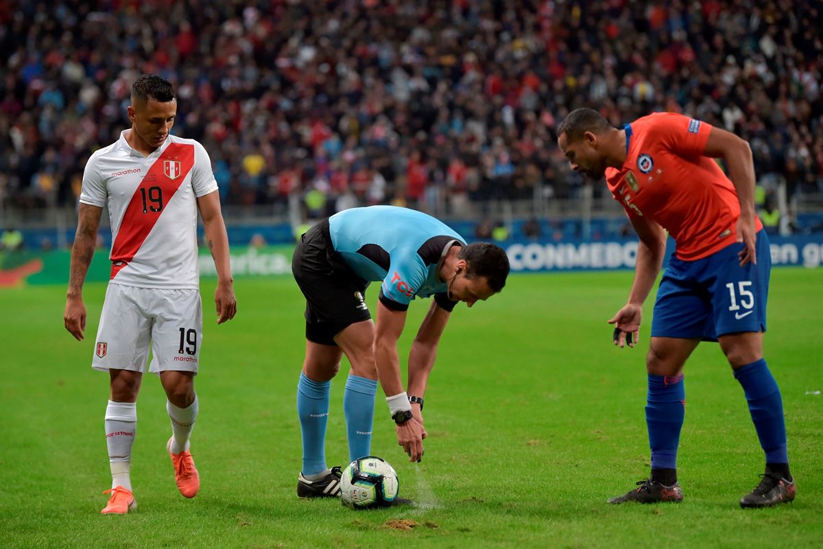 El árbitro colombiano Wilmar Roldán hace uso del spray en un partido entre Perú y Chile. 