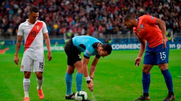 El árbitro colombiano Wilmar Roldán hace uso del spray en un partido entre Perú y Chile.