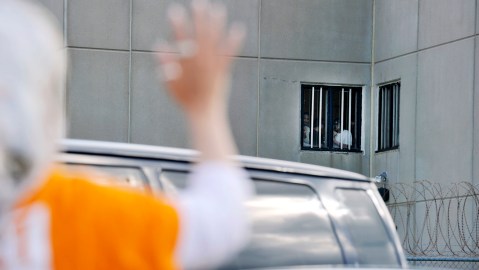 Una mujer saluda a detenidos en un Centro de Detención de ICE.