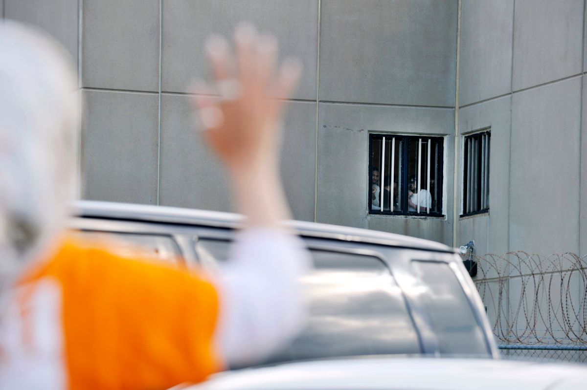 Una mujer saluda a detenidos en un Centro de Detención de ICE.