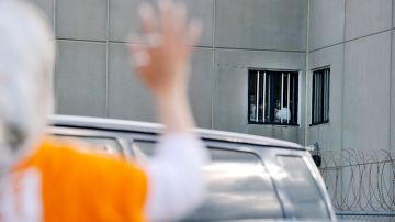 Una mujer saluda a detenidos en un Centro de Detención de ICE.