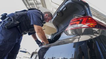 An Immigration and Customs Enforcement (ICE) agent checks an automobile for contraband in the line to enter the United States at the San Ysidro Port of Entry on October 2, 2019 in San Ysidro, California. - Fentanyl, a powerful painkiller approved by the US Food and Drug Administration for a range of conditions, has been central to the American opioid crisis which began in the late 1990s. China was the first country to manufacture illegal fentanyl for the US market, but the problem surged when trafficking through Mexico began around 2005, according to Donovan. (Photo by SANDY HUFFAKER / AFP) (Photo by SANDY HUFFAKER/AFP via Getty Images)