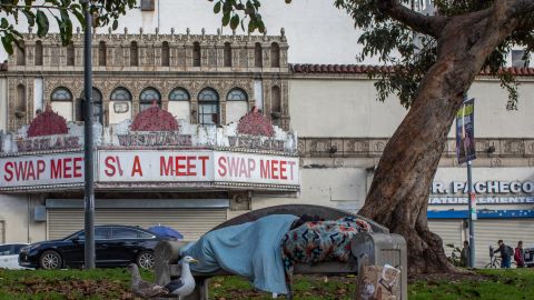 A homeless person sleeps at MacArthur Park Los Angeles, California on March 19, 2020. - All residents of California were ordered to stay at home March 19, 2020, in a bid to battle the coronavirus pandemic in the most populous state in the US. Los Angeles residents were ordered to stay at home by the city's mayor Eric Garcetti on Thursday in a bid to battle the coronavirus pandemic. (Photo by Apu GOMES / AFP) (Photo by APU GOMES/AFP via Getty Images)