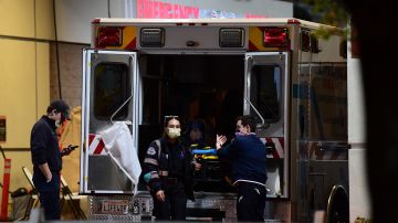 Paramedics wearing facemasks work behind an ambulance at the Garfield Medical Center in Monterey Park, California on March 19, 2020. - All residents of California were ordered to stay at home March 19, 2020, in a bid to battle the coronavirus pandemic in the most populous state in the US. Los Angeles residents were ordered to stay at home by the city's mayor Eric Garcetti on Thursday in a bid to battle the coronavirus pandemic. (Photo by Frederic J. BROWN / AFP) (Photo by FREDERIC J. BROWN/AFP via Getty Images)