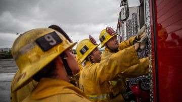 Firefighters look up to fire truck instruments in a morning training session of the LAFD Station No9 team at Skid Row on April 12, 2020 in downtown Los Angeles, California. - One of the busiest fire station in the country , LA Fire Station 9 is on the front lines of California's homeless crisis e Coronavirus pandemic. (Photo by Apu GOMES / AFP) (Photo by APU GOMES/AFP via Getty Images)