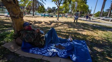 Benjamin Chaves lies on cardboard sheet in MacArthur Park, Los Angeles on May 21, 2020. - Undocumented immigrants impacted by the corornavirus shutdown can apply for California coronavirus emergency assistance plan for undocumented people put in place by Governor Gavin Newsom in April. (Photo by Apu GOMES / AFP) (Photo by APU GOMES/AFP via Getty Images)