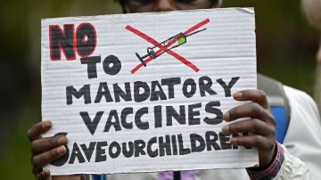 TOPSHOT - A protester holds up a placard at a demonstration against vaccinations and government restrictions designed to fight the spread of the novel coronavirus in London on October 17, 2020. (Photo by JUSTIN TALLIS / AFP) (Photo by JUSTIN TALLIS/AFP via Getty Images)