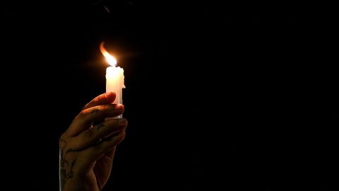 A person holds a lit candle as relatives and friends of Juan David Montenegro attend a vigil on June 18, 2021, in Cali, Colombia, after his death during clashes with riot police on June 16 during a protest against the government of president Ivan Duque, amid a national strike. - The European Union (EU) is concerned about the deaths of dozens of protesters during the demonstrations that broke out in Colombia on April 28, and trusts the government's commitment that those responsible "will be held accountable," special envoy Eamon Gilmore said on June 17. (Photo by Paola MAFLA / AFP) (Photo by PAOLA MAFLA/AFP via Getty Images)