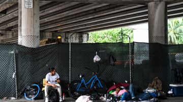 Personas sin hogar acampan en un refugio improvisado en la calle en Miami.