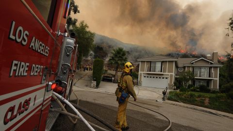 TOPSHOT - A firefighter control monitors a fire burning behind houses in the suburb of Glendale on the outskirts of Los Angeles city on September 1, 2009. A deadly wildfire roared out of control above Los Angeles, leaving two firefighters dead, forcing thousands to flee and threatening a crucial telecommunications facility. The monster blaze raging in mountains north of the densely populated metropolis had ripped through more than 105,000 acres (43,000 hectares) of tinder-dry forest and was "spreading in every direction," authorities said. An army of more than 2,500 firefighters was battling the blaze in the Angeles National Forest which remained only five percent contained and sent a giant white mushroom cloud of smoke across the city. AFP PHOTO/Mark RALSTON (Photo by MARK RALSTON / AFP) (Photo by MARK RALSTON/AFP via Getty Images)