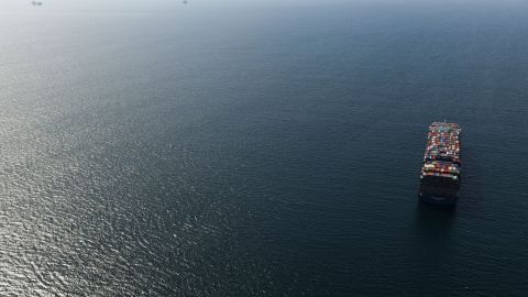 An oil platform (L) and cargo container ship (R) offshore along the coastline are seen from a US Coast Guard HC-27J Spartan aircraft during a media flight after an oil spill in the Pacific Ocean in Orange County, California on October 6, 2021. - The US Coast Guard is investigating a possible anchor strike as the cause of a broken pipeline that has spewed tens of thousands of gallons of crude oil into the sea off California, media reported on October 5. (Photo by Patrick T. FALLON / AFP) (Photo by PATRICK T. FALLON/AFP via Getty Images)