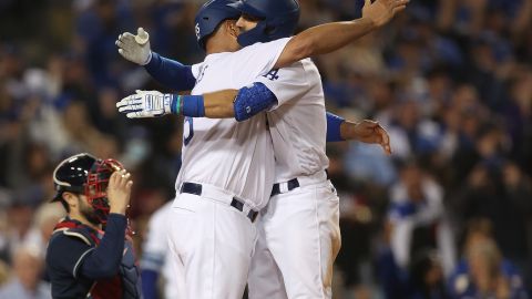 Chris Taylor (der.) recibe su segundo abrazo de la noche de Albert Pujols tras batear jonrón.