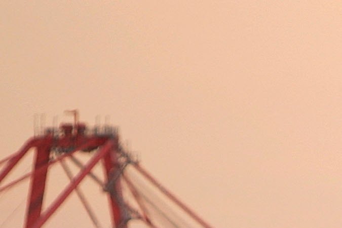 LONG BEACH, CA - JULY 06: Trucks carry shipping containers near a dock where cranes can be seen in the distance at the ports of Long Beach and Los Angeles on July 6, 2006 in Long Beach, California. In the Los Angeles area, studies indicate that diesel exhaust from trucks, locomotives, heavy equipment and ships causes cancer and is responsible for 70% of pollution-related health problems and hundreds of deaths every year. Rather than wait for the international agency that regulates the global shipping industry, the International Maritime Organization, to implement considered changes to strengthen emissions standards for cargo vessels, the ports recently unveiled an ambitious clean-air plan that could significantly improve air quality. The proposal seeks to reduce diesel emissions from cargo ships, trains and trucks by more than 50% over a five-year period at a cost of $2-billion.Almost 5,800 ships called at the ports of Los Angeles and Long Beach in 2005 released about 14,000 tons of air pollutants. Many ships emit as much exhaust per day as 12,000 cars. (Photo by David McNew/Getty Images)