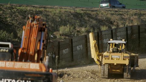 SAN YSIDRO, CA - OCTOBER 26: Members of the National Guard drive tractors to an area where a portion of Border wall will be built October 26, 2006 in San Ysidro, California. U.S. President Bush signed a bill that will add 700 miles of new fencing along the U.S.-Mexico Border. (Photo by Sandy Huffaker/Getty Images)