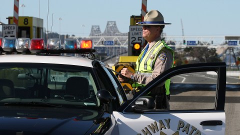 OAKLAND, CA - OCTOBER 28: California Highway Patrol officer Rick Baller stands next to his car as he guards the closed toll plaza leading to the San Francisco Bay Bridge October 28, 2009 in Oakland, California. The San Francisco Bay Bridge was abruptly closed Tuesday evening after two steel tie rods and a crossbeam from a steel saddle broke and fell onto the upper deck of the bridge landing on three vehicles and causing one person to suffer injuries. The eastern span of the bridge is undergoing seismic renovation and is expect to be completed in 2013. (Photo by Justin Sullivan/Getty Images)