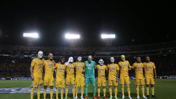 Los jugadores de Tigres con máscaras antes de iniciar el partido contra Chivas.