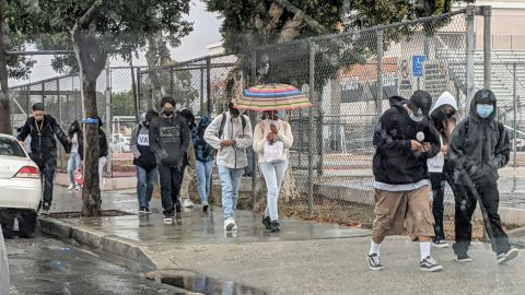 Estudiantes salen de la escuela en plena lluvia. (Jacqueline García/La Opinión)