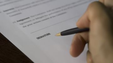 Foto de una persona firmando un contrato