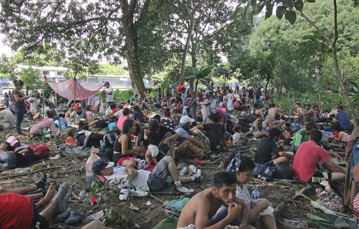 Migrantes descansan antes de retomar su marcha en caravana rumbo a la Ciudad de México.