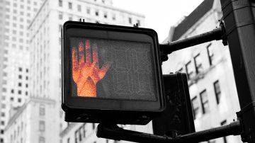 Foto de una luz de advertencia roja en forma de mano en un semáforo