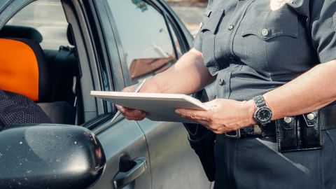 Foto de un oficial de policía emitiendo un ticket de tránsito