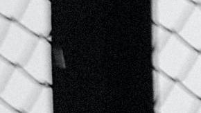 Foto de un hombre apoyado sobre el muro que limita la frontera entre Tijuana y Estados Unidos