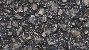 Foto de los zapatos de una persona parada sobre una señal que indica varios caminos