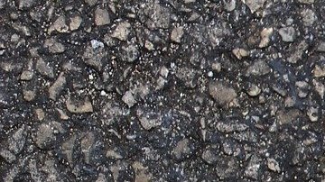 Foto de los zapatos de una persona parada sobre una señal que indica varios caminos