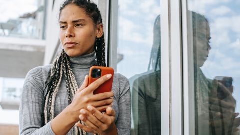 Foto de una mujer preocupada usando un teléfono