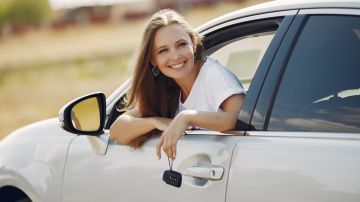 Foto de una mujer joven en la ventana de un auto