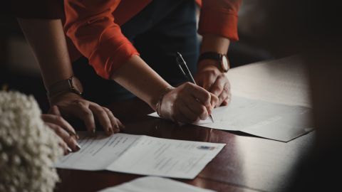 Foto de una persona firmando papeles