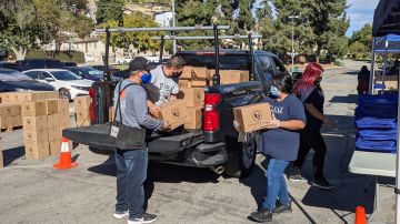 Voluntarios bajan cajas de alimentos que son entregadas con los pavos.