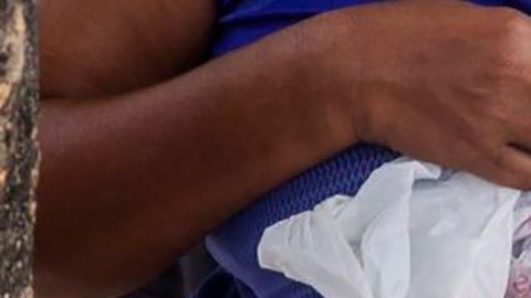 El desperdicio de unos es comida para otros. Una mujer muestra unos panes recién encontrados en un camión de basura.