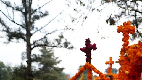 Familias en México adornan tumbas de sus seres queridos en el Día de Muertos.
