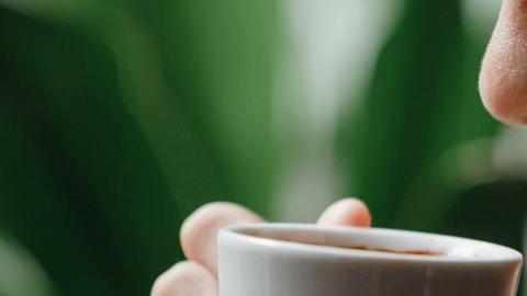Mujer oliendo café