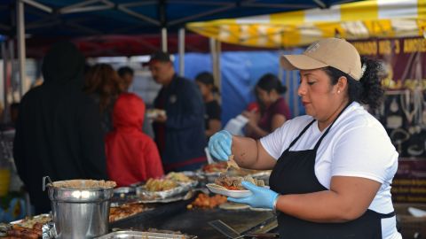 A cook prepares tacos at a street vending stand in the Pinata District in Downtown Los Angeles on March 23, 2019. - On January 1, 2019, the Safe Vending Act (SB946) went into effect in the state of California prohibiting the arrest or finning of street vendors and leaving to municipalities the power to establish permits, sanitation and security issues. The Los Angeles County has set a year to negotiate with vendors the terms on which the law is going to be applied. Some 50,000 street vendors are estimated to work in Los Angeles, a $504 million industry according to a 2015 study by the Economic Roundtable. The LA County issued a municipal ordinance that designates specific areas where the vendors must operate. The ordinance does not include areas such as Memorial Coliseum, the Staples Center, Dodger Stadium, Rose Bowl Stadium and the Hollywood Walk of Fame. Street vendors have mixed feelings about the legalization of their work. At the same time they feel freed of being against the law and harassed by police giving them tickets and seizing their goods; they are concerned about having to abide to health regulations, permits and limited areas. (Photo by Agustin PAULLIER / AFP) (Photo credit should read AGUSTIN PAULLIER/AFP via Getty Images)