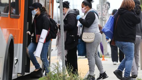 LOS ANGELES, CALIFORNIA - APRIL 06: People board a bus wearing face masks amid the coronavirus pandemic on April 6, 2020 in south Los Angeles, California. Nearly 11,000 people have died in the U.S. from COVID-19. (Photo by Mario Tama/Getty Images)