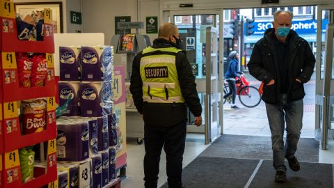 LONDON, ENGLAND - JANUARY 12: A security guard stands by the entrance to a Morrisons supermarket as a customer wearing a face mask enters the store on January 12, 2021 in London, United Kingdom. In response to government ministers voicing concerns about the public's behaviour in supermarkets, Sainsbury's and Morrisons have both announced they will be enforcing rules on mask-wearing in their stores. The daily admissions to hospitals of coronavirus cases has topped 4000 and the current number of patients in hospital with the virus is 32,294. (Photo by Chris J Ratcliffe/Getty Images)