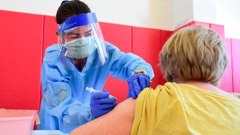 Registered nurse Irene Musni administers the COVID-19 vaccine into the arm of a senior citizen at the Corona High School gymnasium in the Riverside County city of Corona, California on January 15, 2021, a day after California began offering the coronavirus vaccine to residents 65 and older. - US President-elect Joe Biden was set to announce his Covid-19 vaccine rollout plan Friday as he bids to wrest the focus from the impeachment of Donald Trump to the agenda for his first days in office. Biden has said he wants 100 million Americans to receive shots during his first 100 days in office, an ambitious goal that would require a big step up in the current pace of distribution. (Photo by Frederic J. BROWN / AFP) (Photo by FREDERIC J. BROWN/AFP via Getty Images)