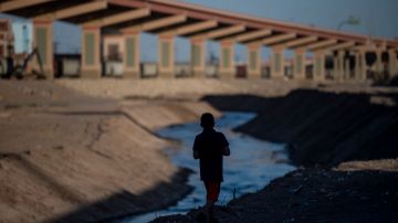 Un niño camina a lo largo del Río Bravo, donde muchos han perdido la vida.