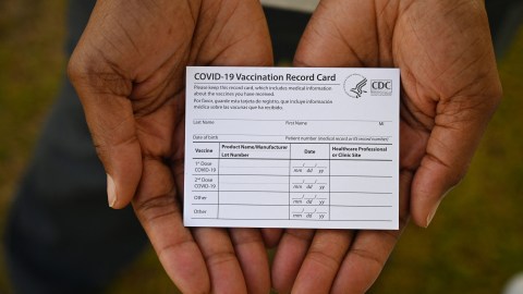 A healthcare worker displays a Covid-19 Vaccination Record Card during a vaccine and health clinic at QueensCare Health Center in a predominately Latino neighborhood in Los Angeles, California, August 11, 2021. - All teachers in California will have to be vaccinated against Covid-19 or submit to weekly virus tests, Governor Gavin Newsom announced on August 11, as authorities grapple with exploding infection rates. The number of people testing positive for the disease has surged in recent weeks, with the highly infectious Delta variant blamed for the bulk of new cases. (Photo by Robyn Beck / AFP) (Photo by ROBYN BECK/AFP via Getty Images)