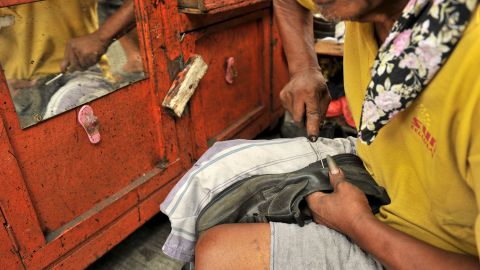 Rodolfo Arpon, 66, repairs a shoe on a street in Manila on March 28, 2012. The Philippines will hit or top its growth target of 5-6 percent this year despite rising oil prices and China's forecast of slightly slower economic expansion, officials said. AFP PHOTO/NOEL CELIS (Photo credit should read NOEL CELIS/AFP via Getty Images)