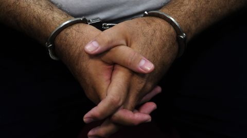 Detail of the hands of former Salvadoran President (2004-2009) Elias Antonio Saca with handcuffs, taken as he waits, along with six of his collaborators, for the judge to arrive in court in San Salvador on May 16, 2018, to face charges of embezzlement and laundering for allegedly diverting 298 million dollars. - Saca was arrested in October 2016 with his former private secretary and former communications secretary, among others, suspected of pocketing $246 million in public funds during his 2004-2009 mandate. They have been charged with embezzlement, criminal association and money laundering. (Photo by Marvin RECINOS / AFP) (Photo credit should read MARVIN RECINOS/AFP via Getty Images)