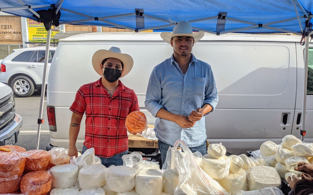 Iván Tapia y su primo Rafael Tapia vendiendo quesos en el distrito de las piñatas. (Jacqueline García/La Opinión)