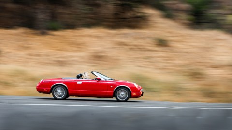 Foto de un convertible rojo a alta velocidad por la carretera